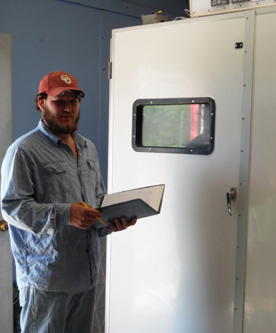 Country Hatchery staff member checking a NatureForm poultry egg incubator in Wewoka Oklahoma
